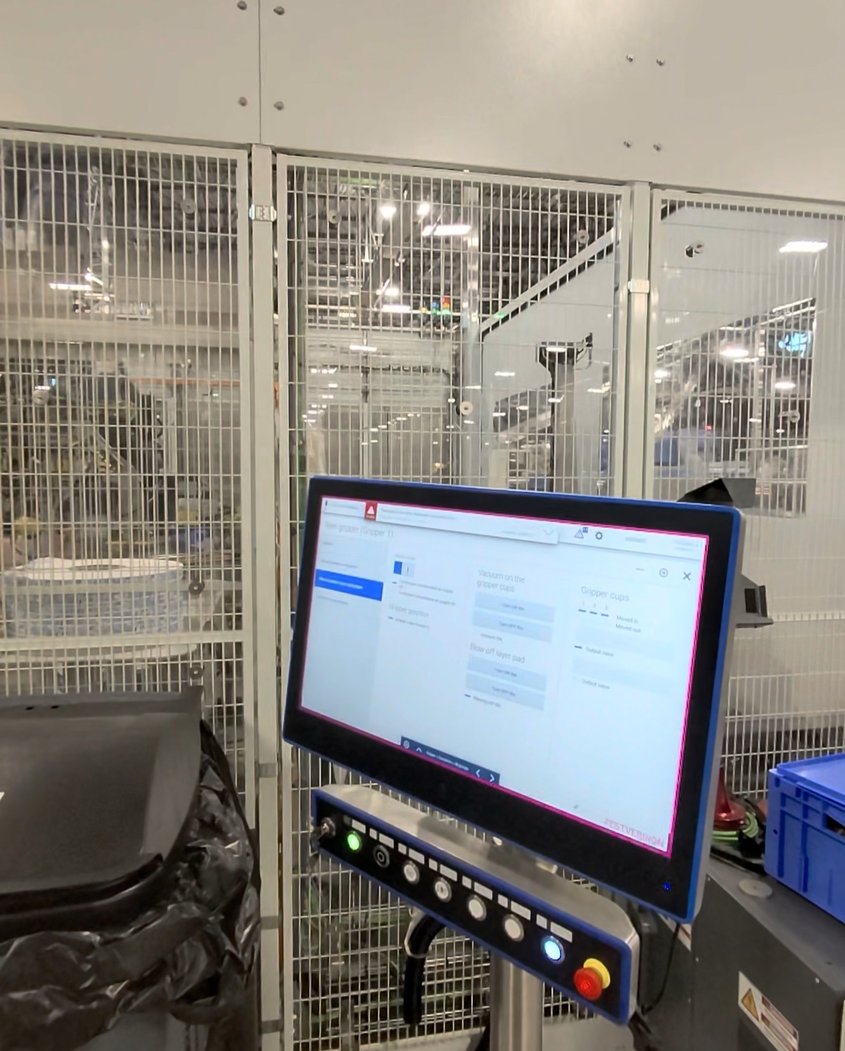Operator HMI beside guarded industrial machinery